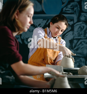 Mädchen im Teenageralter Gestaltung Keramik auf einer Töpferscheibe in einer High-School-Kunst-Klasse. Stockfoto