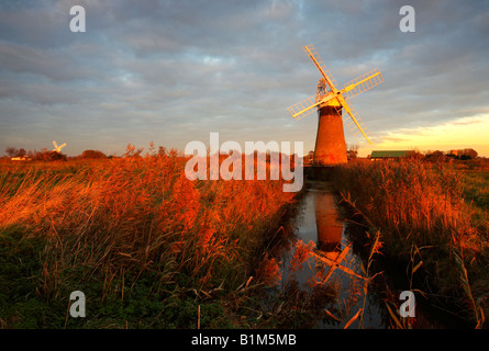 St Benets Windmill kurz vor einem dramatischen Sonnenuntergang auf den Norfolk Broads National Park, UK. Stockfoto