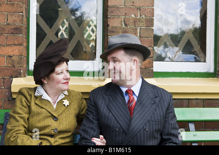 Paar der 1940er Jahre warten auf Bahnsteig mit Bombe mit Klebeband Windows Stockfoto