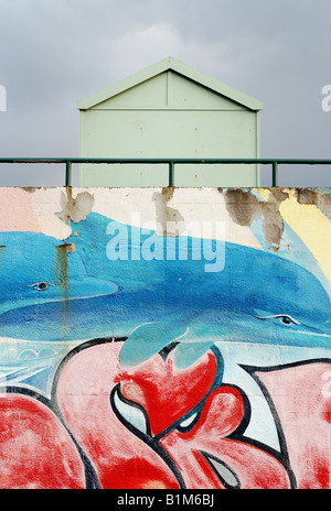 Graffiti an der Wand hinter einer Strandhütte am Meer Stockfoto