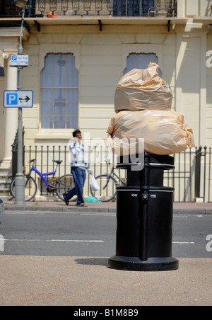 Säcke mit Müll sitzen oben auf ein Brighton Mülleimer zur Abholung bereit. Bild von Jim Holden. Stockfoto