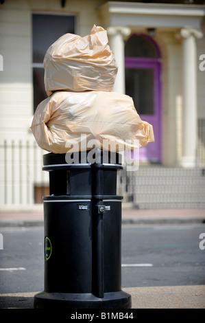 Säcke mit Müll sitzen oben auf ein Brighton Mülleimer zur Abholung bereit. Bild von Jim Holden. Stockfoto