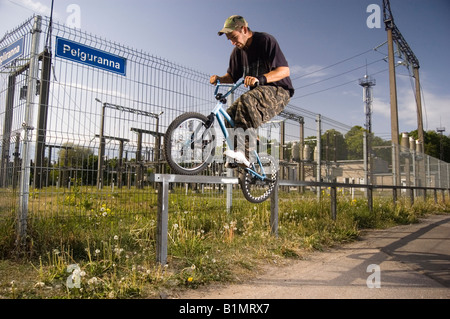 BMX-Fahrer tun "Schwachen Grind" auf einer Schiene Stockfoto