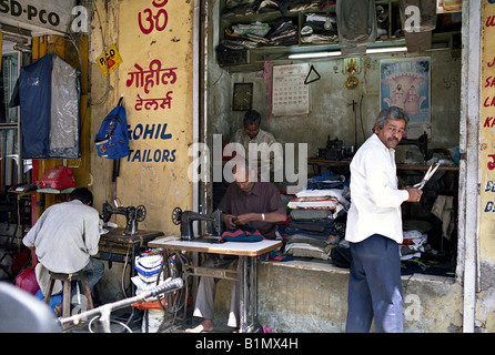 Indien MUMBAI MAHARASHTRA Schneider arbeitet an Nähmaschinen eingerichtet, auf dem Bürgersteig vor einem kleinen Laden auf dem Markt in Mumbai Stockfoto