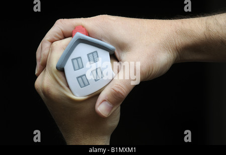 MUSTERHAUS DRÜCKTE UND HIELT IN A MANS HAND RE HAUS PREISE EIGENTUM MARKT WIRTSCHAFT HOME KÄUFER ETC., UK. Stockfoto