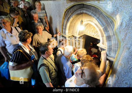 Touristen warten, um in die Höhle im Inneren der Kirche der Geburtskirche in Bethlehem aufgereiht. Stockfoto