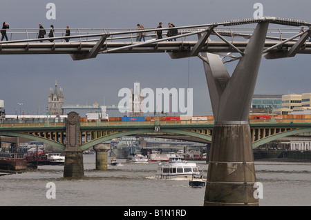 Menschen, die zu Fuß über die Millennium Bridge, mit Tower Bridge im Hintergrund Stockfoto