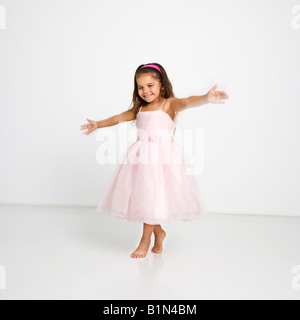 Niedliche kleine hispanischen Mädchen tragen rosa Kleid tanzen Stockfoto