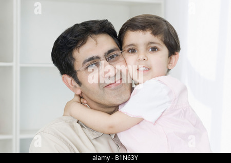 Porträt eines Mädchens, das ihr Vater umarmt Stockfoto