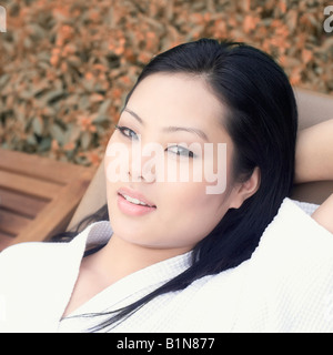 Porträt einer jungen Frau auf einem Liegestuhl liegend Stockfoto