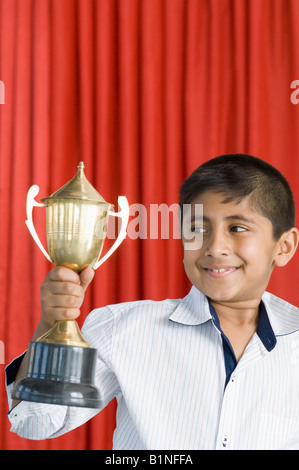 Junge hält einen Pokal und lächelnd Stockfoto