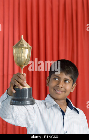 Junge hält einen Pokal und lächelnd Stockfoto