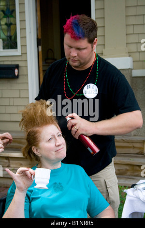 Frau Tasse Bier während der Kosmetikerin schafft ihr Buzz-Stil in Outdoor-Beauty-Shop. Große alte Tag St. Paul Minnesota USA Stockfoto