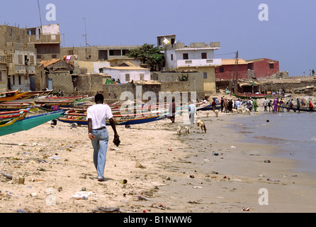 Angelboote/Fischerboote und Menschen an einem übersäten Strand in der Stadt N'gor, in der Nähe des Flughafens für Dakar, Senagal Stockfoto