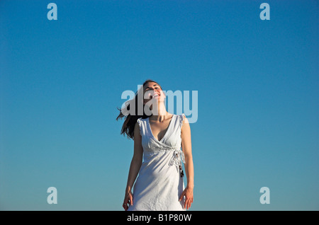Porträt einer lächelnden jungen Frau tragen Sommer Kleid gegen blauen Himmel Stockfoto