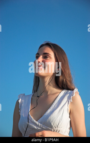 Lächelnde junge Frau trägt Kopfhörer im freien Stockfoto