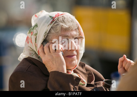 eine ältere senior Frau ein Kopftuch telefonieren mit ihrem Handy, UK Stockfoto