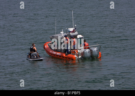 Vereinigte Staaten Küstenwache Defender Klasse Patrouillenboot stoppen einen Mann auf eine Wassermotorräder Stockfoto