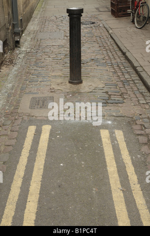 Pfosten oder Pfosten am Ende einer engen Straße mit sehr nahen doppelten gelben Linien in Oxford Stockfoto