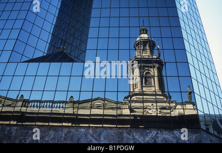 Kontrastierende Architektur in Santiago: Der Turm der Metropolitan Cathedral spiegelt sich im modernen Wolkenkratzer Mall Puente in Santiago, Chile Stockfoto