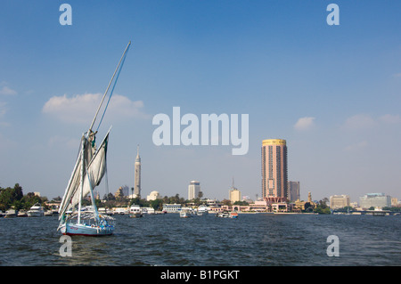 Die Skyline der Stadt vom Fluss Nil des Sofitel Hotels und Kairo-Turm mit einer Feluke Segelboot in Kairo Ägypten Stockfoto