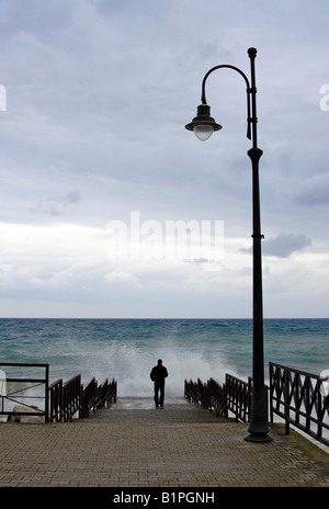 Junger Mann auf Pier stehen und starrte auf schwere See, Amalfi-Küste (Italien) Stockfoto