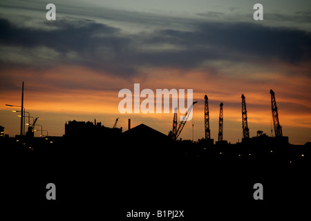 Stadt in Glasgow, Schottland. Silhouette Abenddämmerung Blick auf Schiffbau Krane auf Glasgows River Clyde in Govan Werft. Stockfoto