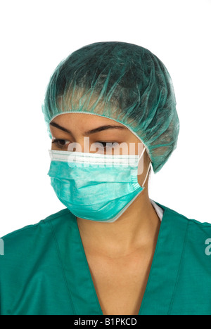 Porträt einer Frau Krankenschwester in scheuert sich grüne Uniform und Maske, die wir auf der Seite vor weißem Hintergrund Stockfoto