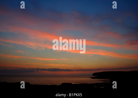 Sonnenuntergang malt bunte Wolken an der felsigen Küste des Atlantischen Ozeans. County Clare, Irland. Stockfoto
