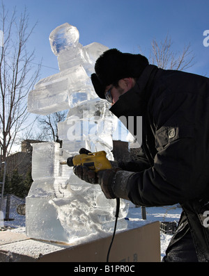 Crystal Drilling: Quebec Bildhauer Daniel Gaudreault verwendet eine Bohrmaschine für einige große Absplitterungen an seinem Winterlude ice Carving Stockfoto
