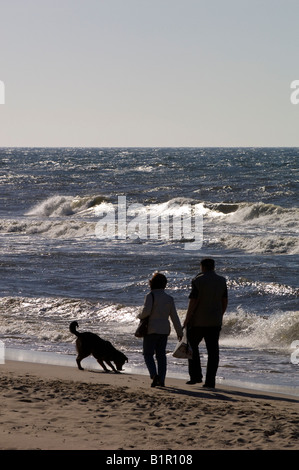 Ein paar und ein Hund genießen Sie einen Spaziergang am Strand in Pobierowo Ostsee Polen Stockfoto