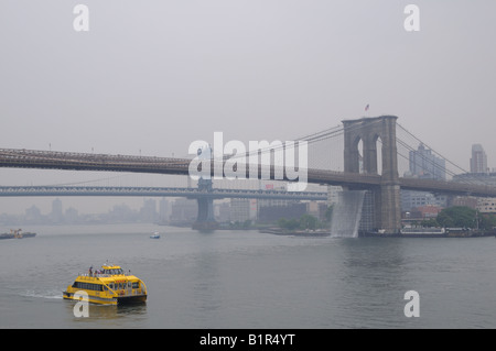 Ein New York Water Taxi geht in der Nähe der Brooklyn Bridge, wo einer der Künstler Olafur vier Wasserfälle installiert wurden. Stockfoto