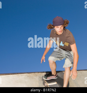 Teenboy hat Tricks in der Halfpipe an einen Skate-park Stockfoto