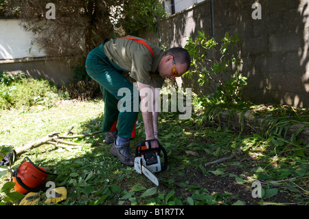 Mann in STIHL Schutzkleidung ab seiner Kettensäge MS180 Stockfoto