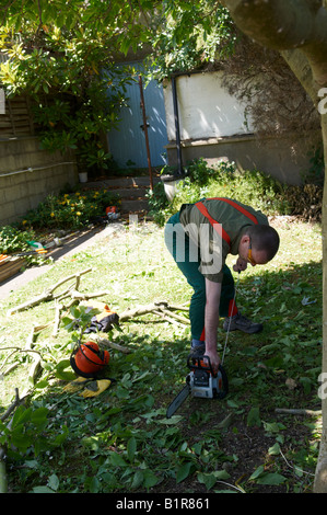 Mann in STIHL Schutzkleidung ab seiner Kettensäge MS180 Stockfoto