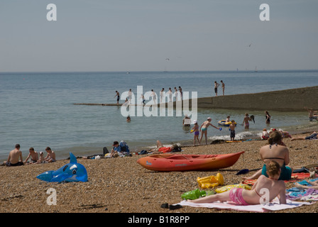 Menschen genießen das Wetter auf Salz Dean Strand in der Nähe von Brighton Sussex England Stockfoto