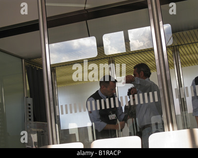 Passagiere werden vom Sicherheitsmann am Internationalen Flughafen Berlin-Deutschland überprüft Stockfoto