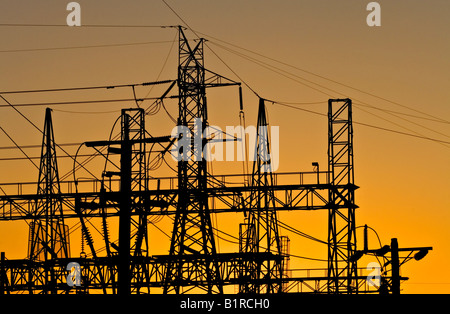 Energiewirtschaft / Strom. Hochspannung Sendemasten Silhouette bei Sonnenuntergang. Stockfoto