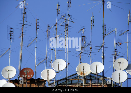 TV-Antennen und Satellitenschüsseln auf Dach Stockfoto