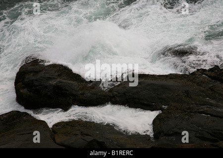 Felsen und Wellen am Strand von Kovalam, Kerala, Indien Stockfoto