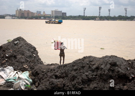 Mann kurz nach seinem Bad, Kolkata, Kalkuttas Skyline bei Rücken, Howrah, Hooghly, Westbengalen, Indien Stockfoto