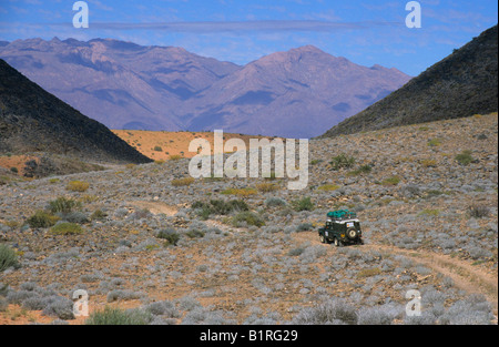 Land Rover in steinigen Wüstenlandschaft, Brandberg Bergkulisse, in der Nähe von Benutzeroberflächen, Namibia, Afrika Stockfoto