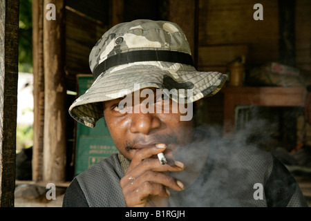 Ein junger Mann, Rauchen, Mindre Dorf, Papua-Neu-Guinea, Melanesien Stockfoto