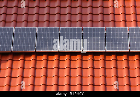 Sonnenkollektoren auf einem roten Ziegeldach Stockfoto