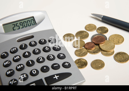 Euro-Münzen und Stift neben einen Taschenrechner Stockfoto