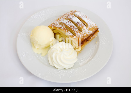 Apfelstrudel mit Vanilleeis und Schlagsahne serviert Stockfoto