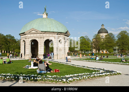 Menschen genießen die warmen Frühlingstag vor dem Pavillon für die Göttin Diana im Hofgarten, München, Bayern, Deutschland, Stockfoto