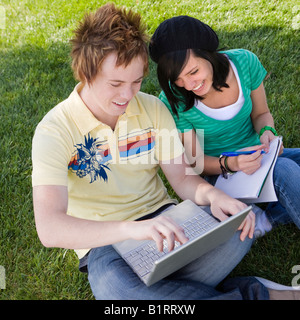 Teen paar Hausaufgaben in der Wiese Stockfoto