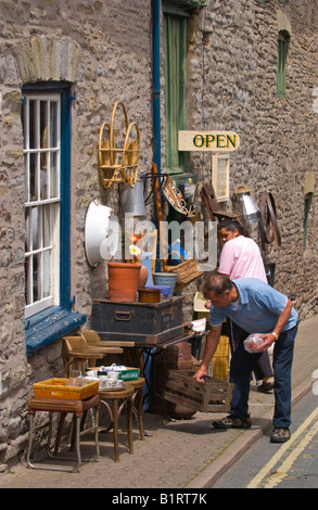 Menschen Surfen Antiquitätengeschäft Lager angezeigt auf Bürgersteig in Hay on Wye Powys Wales UK berühmt für seine gebrauchten Buchhandlungen Stockfoto