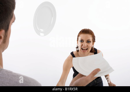 Frau eines Mannes Kopf während eines Streits einen Teller bewerfen Stockfoto